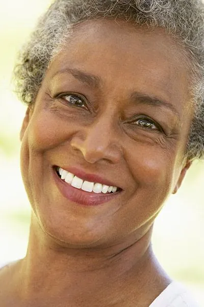 woman showing off her restored smile thanks to dental implants from Smile Studio Upland