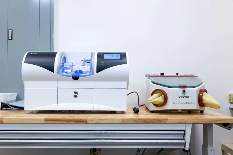 CEREC milling unit and sandblaster on lab bench